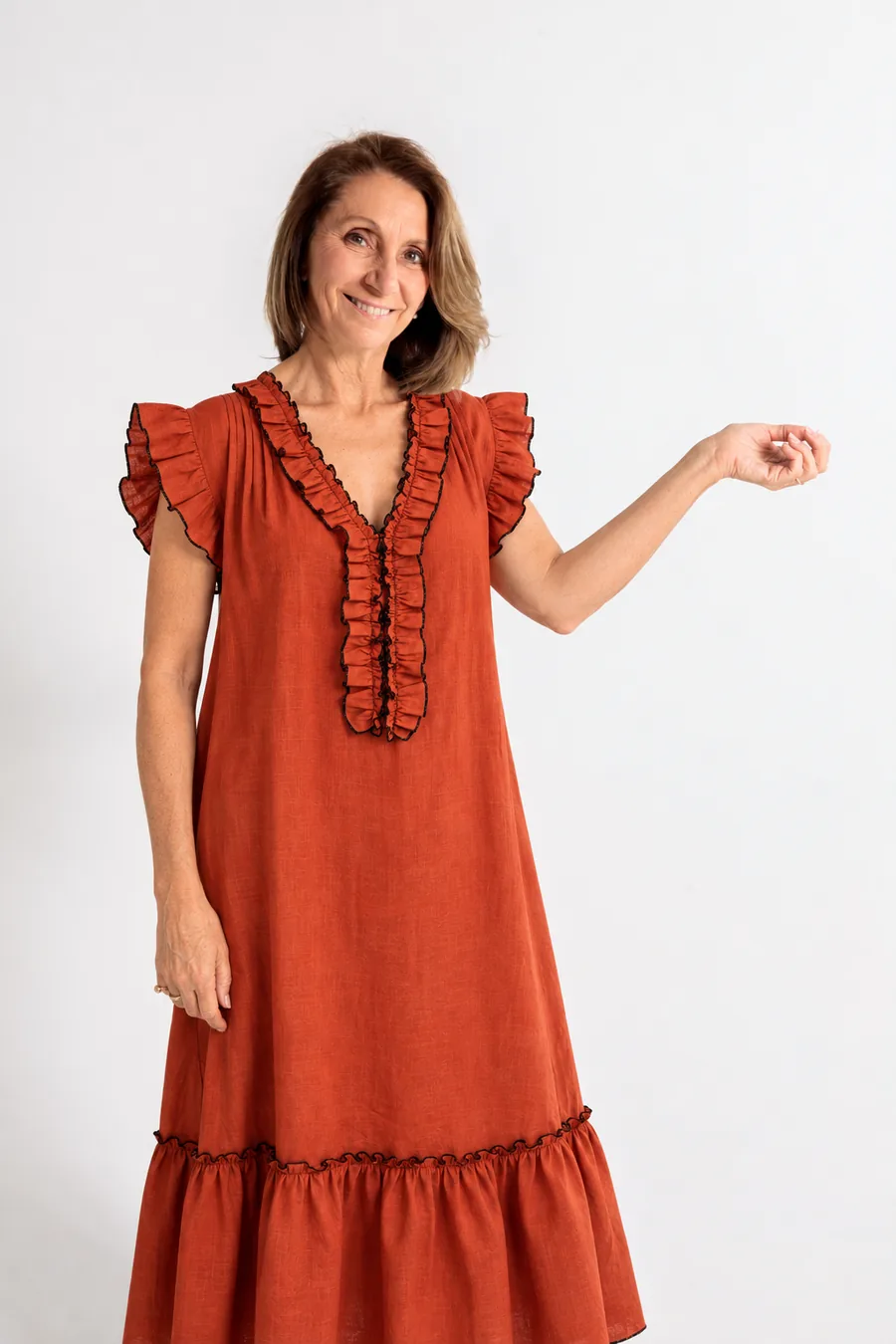 Fabi Marquesini sonriendo con el vestido de lino terracota con volados y detalles en negro